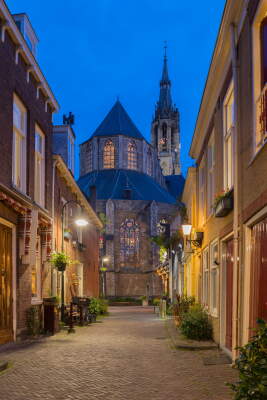 Twilight alley leading to illuminated Gothic church