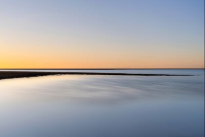 Oranger Sonnenuntergang in einer blauen Oase