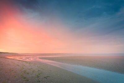 Ruhiger sonnenaufgang an der küste mit sanften rosa- und blautönen