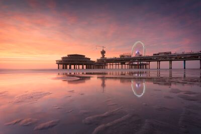 Wunderschöner sonnenuntergang an der Scheveningen-Pier mit reflexionen im wasser