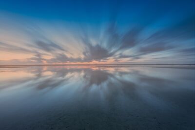 Atemberaubende himmelsreflexionen bei sonnenuntergang an einer ruhigen küstenlinie