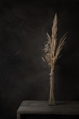 Donker stilleven met droogbloemen op oude houten tafel