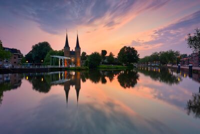 De historische Oostpoort in Delft bij zonsondergang met spiegeling