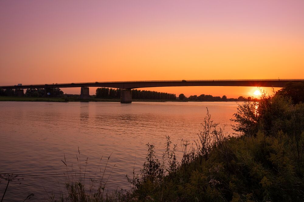 Zonsondergang brug over de Rijn.